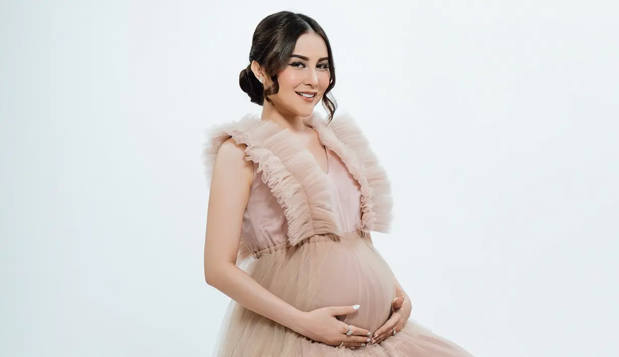 Pakai gaun sleeveless warna cokelat berbahan tile, Vicy Melanie tampil anggun dan terlihat seperti putri. Rambut yang disanggul dengan juntaian poni di samping kiri dan kanannya, aura Vicy Melanie kian terpancar di pemotretan maternity shootnya ini. Wajah cantik artis berusia 35 tahun ini dipoles oleh MUA Annesya. Tonjolkan highlighter blush, Vicy Melanie memukau. (Liputan6.com/IG/@vicymelanie)