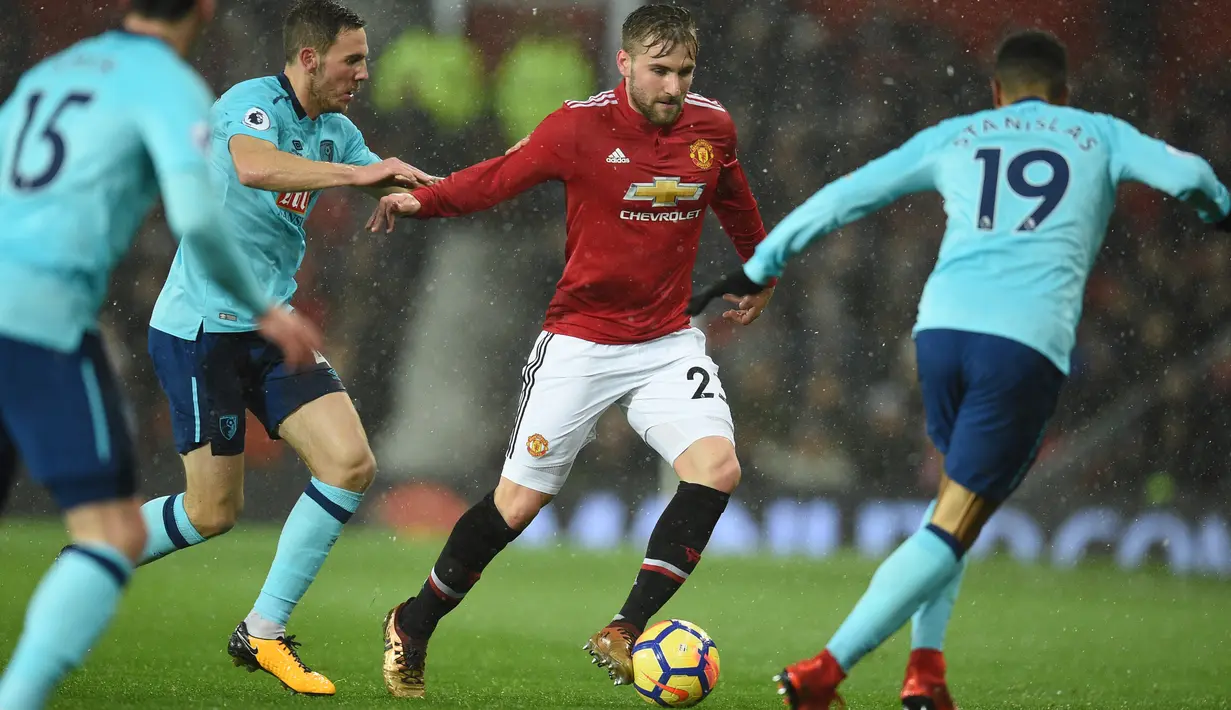Pemain Manchester United Luke Shaw berebut bola dengan pemain AFC Bournemouth, Junior Stanislas pada lanjutan laga Premier League di Old Trafford, Rabu (13/12). Romelu Lukaku menjadi penentu kemenangan dengan skor 1-0 itu. (Oli SCARFF / AFP)
