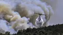 <p>Pesawat pemadam kebakaran Canadair menyemprotkan air saat terjadi kebakaran di Dervenochoria, barat laut Athena, Yunani, 19 Juli 2023. Panas ekstrem diramalkan terjadi di seluruh dunia pada 19 Juli 2023 saat kebakaran hutan berkobar dan peringatan kesehatan diberlakukan di beberapa bagian Asia, Eropa, dan Amerika Utara. (Spyros BAKALIS/AFP)</p>