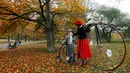 Seorang ibu dan anaknya bersiap menghadiri balapan sepeda Penny Farthing tahunan di Praha, Republik Ceko (5/11). Sepeda ini sangat populer pada tahun 1880an, dan merupakan sepeda pertama yg mendapat sebutan Bicycle (dua roda). (Reuters/David W Cerny)