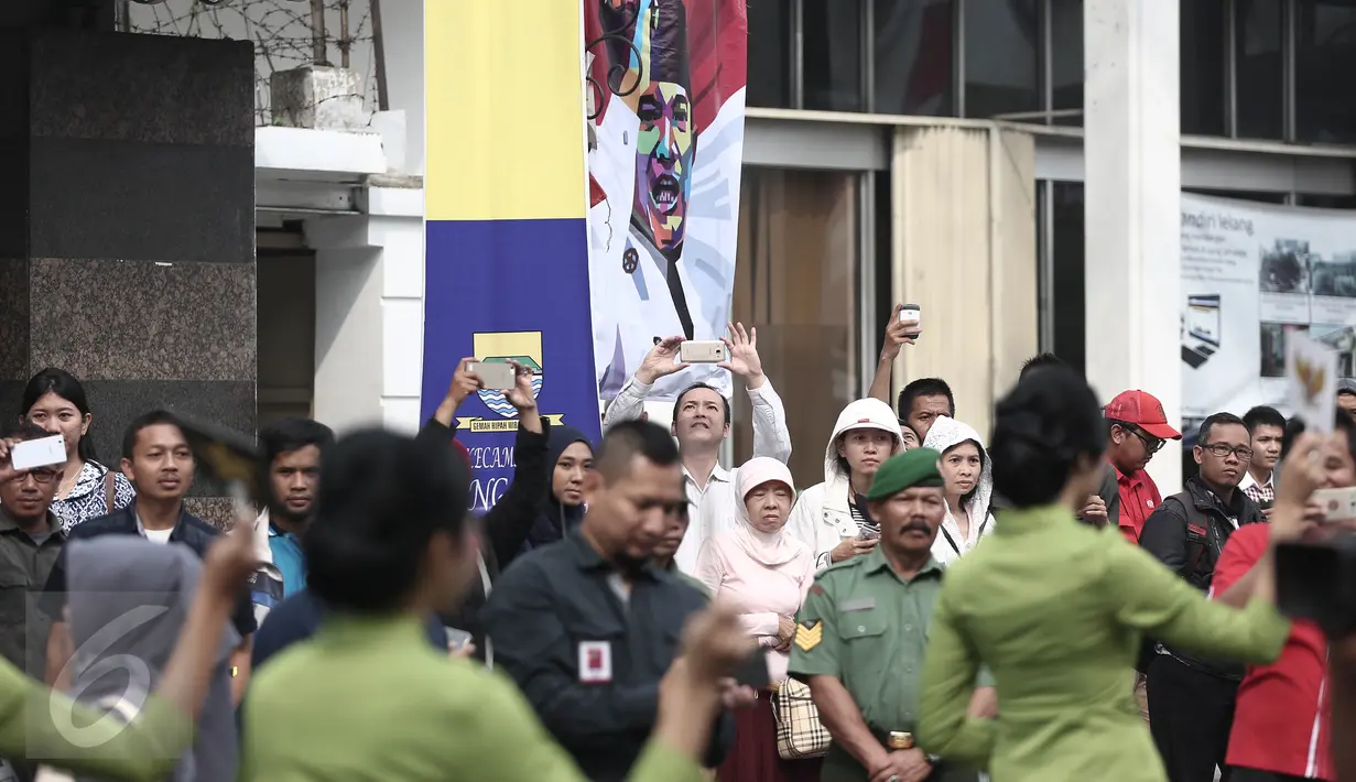 Sejumlah warga mengabadikan kemeriahan atraksi drum band dan pawai budaya di sepanjang Jalan Asia Afrika, Bandung, Rabu (1/6). Lahir Pancasila 1 Juni 2016 dirayakan dengan meriah di Kota Kembang tersebut. (Liputan6.com/Faizal Fanani)