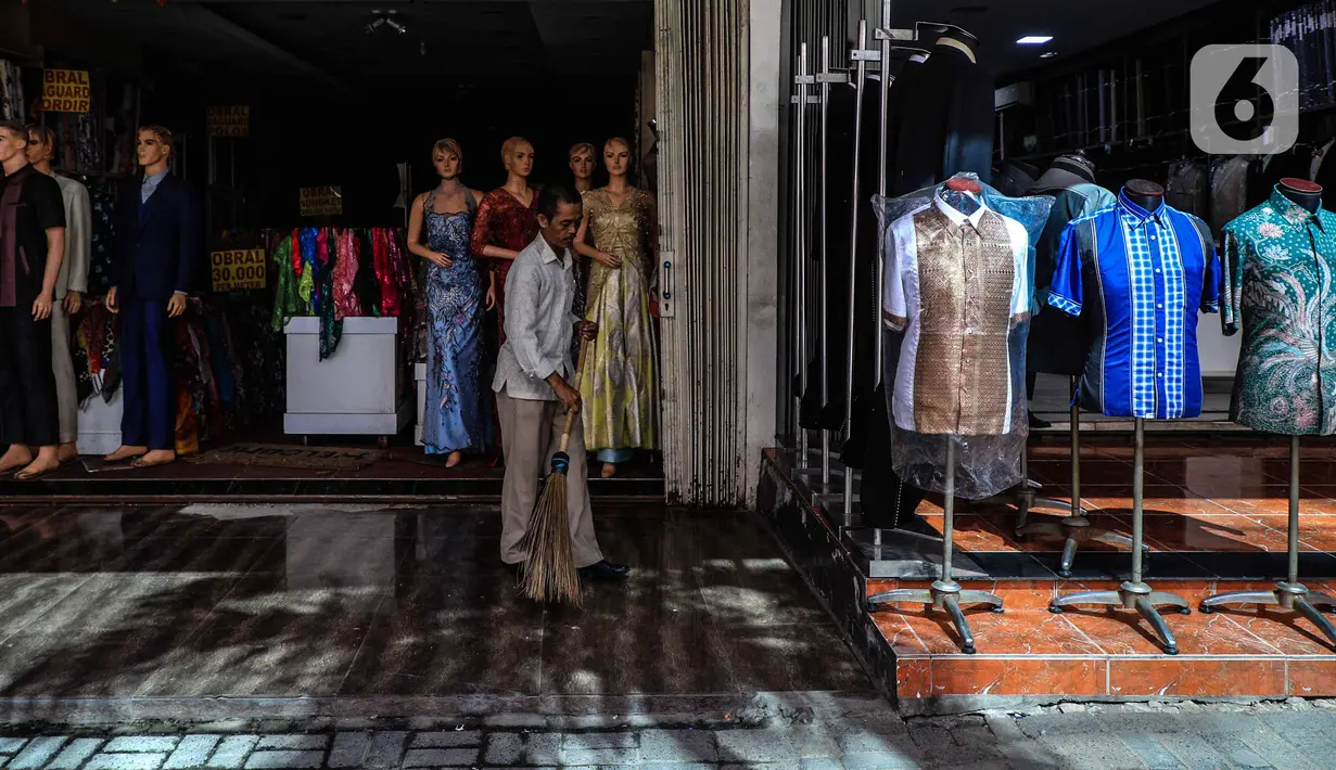 Seorang pria menyapu halaman sebuah toko di kawasan perdagangan Pasar Baru, Jakarta, Jumat (3/4/2020). Sebagian pemilik toko di Pasar Baru memilih menutup usahanya sementara waktu untuk mengantisipasi meluasnya penyebaran virus corona COVID-19. (Liputan6.com/Faizal Fanani)