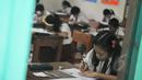 Seorang siswi mengerjakan soal Ujian Nasional (UN) mata pelajaran Bahasa Indonesia di SDN 04 Jakarta, Senin (18/5/2015). Sebanyak 153.266 peserta didik SD/MI dan sederajat di Jakarta mengikuti UN yang digelar 18-20 Mei. (Liputan6.com/Herman Zakharia)