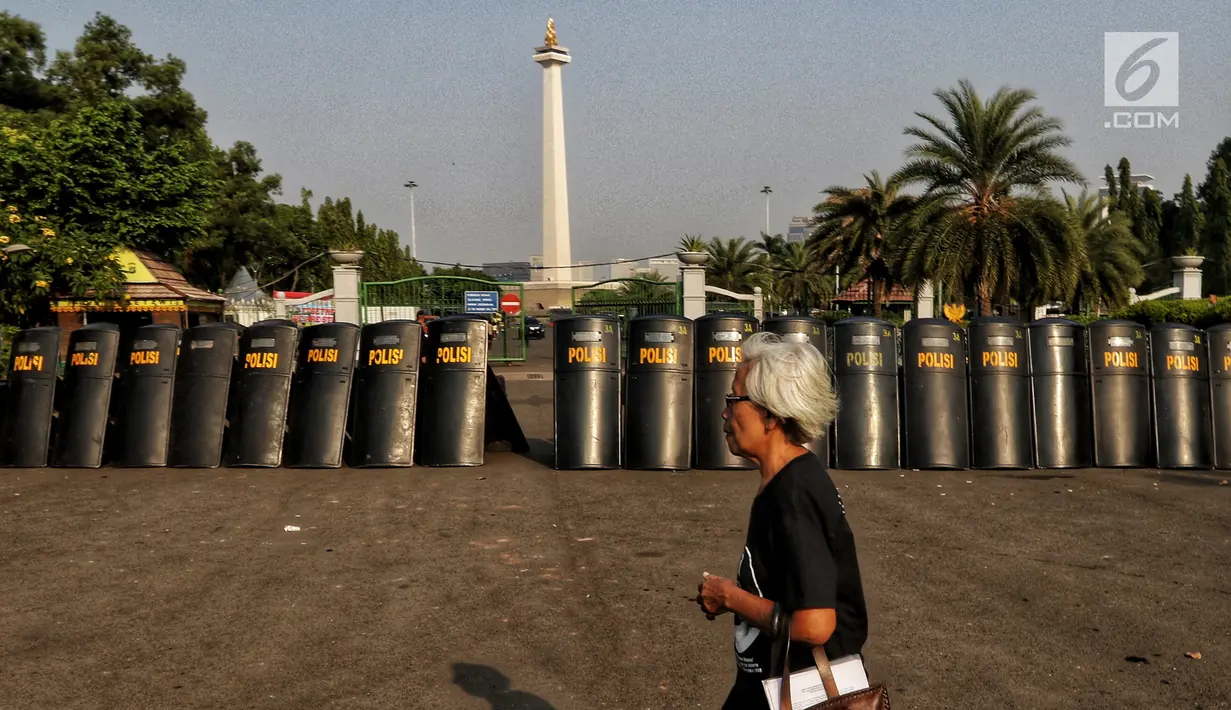 Tameng polisi terlihat saat aksi Kamisan ke-589 di depan Istana Merdeka, Jakarta, Kamis (20/6/2019). Dalam aksinya, JSKK meminta Presiden Joko Widodo juga menghapus impunitas sebagaimana tercantum dalam Nawacita. (Liputan6.com/Johan Tallo)