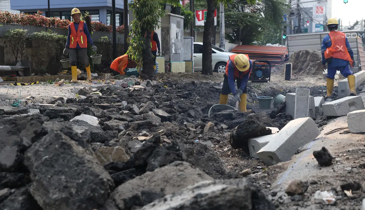 Aktivitas pekerja menyelesaikan proyek revitalisasi trotoar di Jalan Salemba Raya, Jakarta, Jumat (6/9/2019). Proyek revitalisasi trotoar dengan anggaran Rp 75 miliar ini ditargetkan rampung pada Desember mendatang. (Liputan6.com/Helmi Fithriansyah)