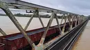 Gerbong kereta api diparkir di jembatan kereta api untuk mengamankan struktur jembatan agar tidak hanyut oleh banjir di Hue, Vietnam, Selasa, 28 Oktober 2025. Hujan deras yang mengguyur kawasan pesisir tengah Vietnam sejak akhir pekan lalu, membuat sekolah-sekolah ditutup dan bekas ibu kota kekaisaran Vietnam, Hue, yang merupakan situs warisan dunia UNESCO, terendam air. (Nguyen Van Ly/VNA via AP)