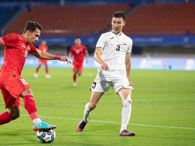 Pemain Timnas Indonesia U-24, Egy Maulana Vikri (kiri), mengontrol bola dan berusaha melewati hadangan&nbsp;pemain Kirgistan dalam laga Grup F Asian Games 2022 yang digelar di Zhejiang Normal University East Stadium, Jinhua, China, Selasa (19/9/2023) malam WIB. (Dok. NOC Indonesia)