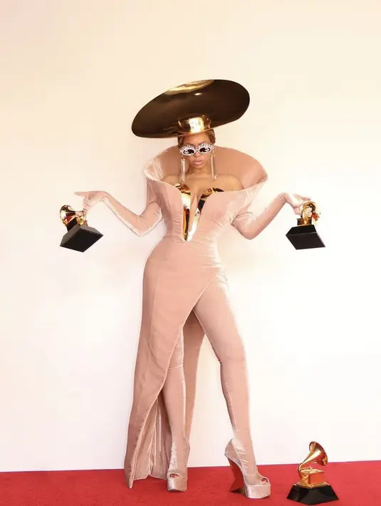 <p>Beyonce membawa pulang tiga piala di ajang tersebut. Saat memamerkan pialanya, Beyonce tampil mengenakan topi emas serta gaun off shouder velvet pink dengan inner kermasan. Dipadukan stocking warna serasi dengan gaun. @beyonce</p>
