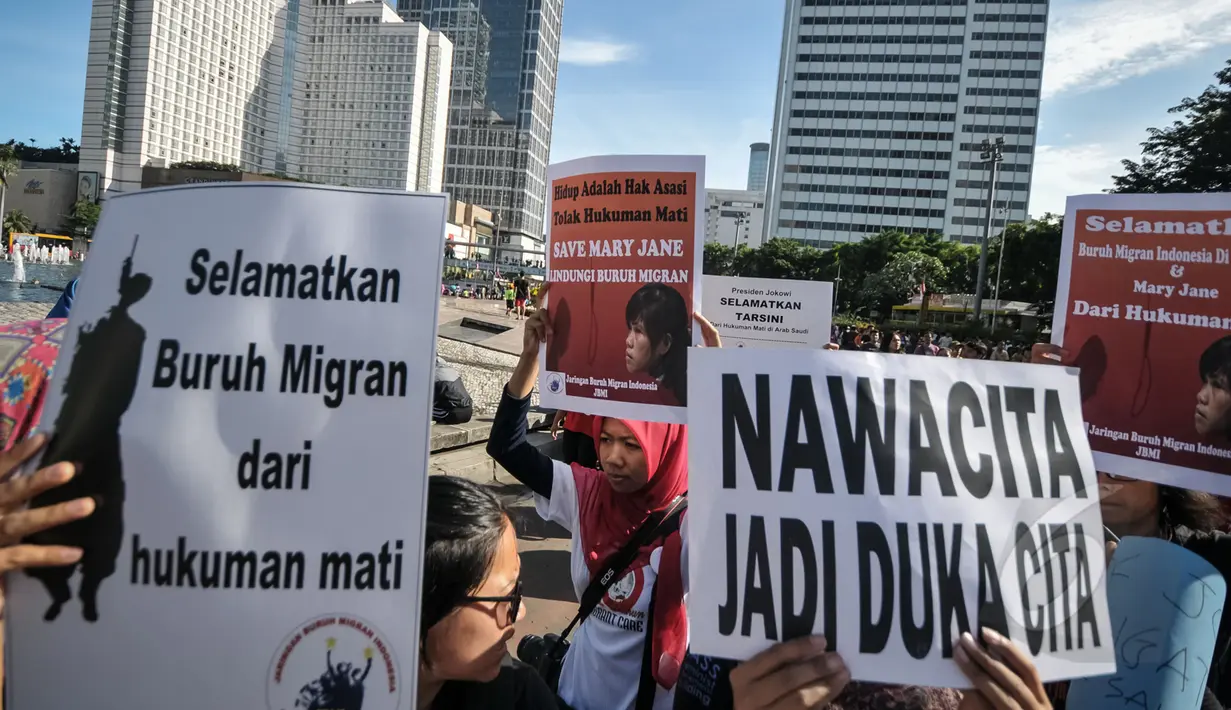 Jaringan Buruh Migran Indonesia melakukan aksi di Bundaran HI, Jakarta, Minggu (26/4/2015). Sejumlah tulisan dibawa saat aksi menolak hukuman mati Mary Jane. (Liputan6.com/Faizal Fanani)