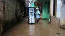Seorang pedagana berjualan saat banjir melanda Kampung Melayu, Jakarta Timur, Senin (25/6). Banjir tertinggi di Kampung Melayu terjadi di RT 12/04, RT 13/04, RT 10/05 serta RT 11/05. (Liputan6.com/Arya Manggala)