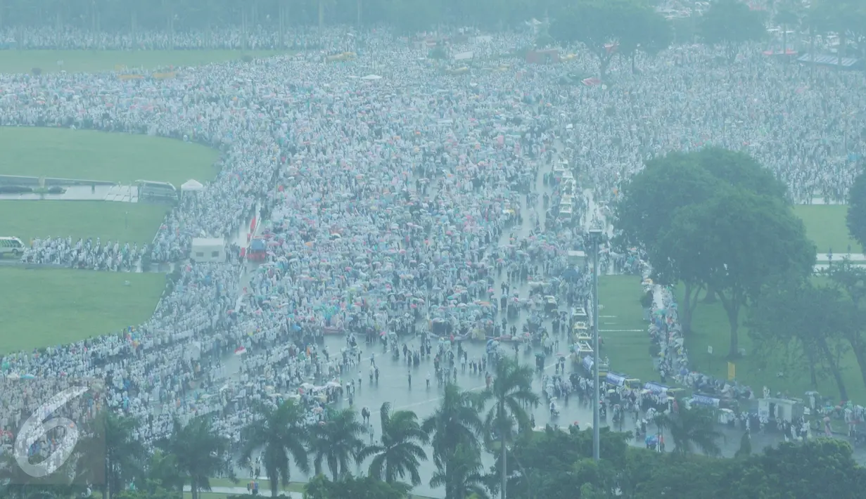 Ribuan massa aksi damai 2 Desember yang akan melaksanakan ibadah salat Jumat memadati kawasan Monas, Jakarta, Jumat (2/12). Para peserta doa bersama tetap melaksanakan ibadah Salat Jumat meskipun kondisi cuaca hujan. (Liputan6.com/Gempur M Surya)