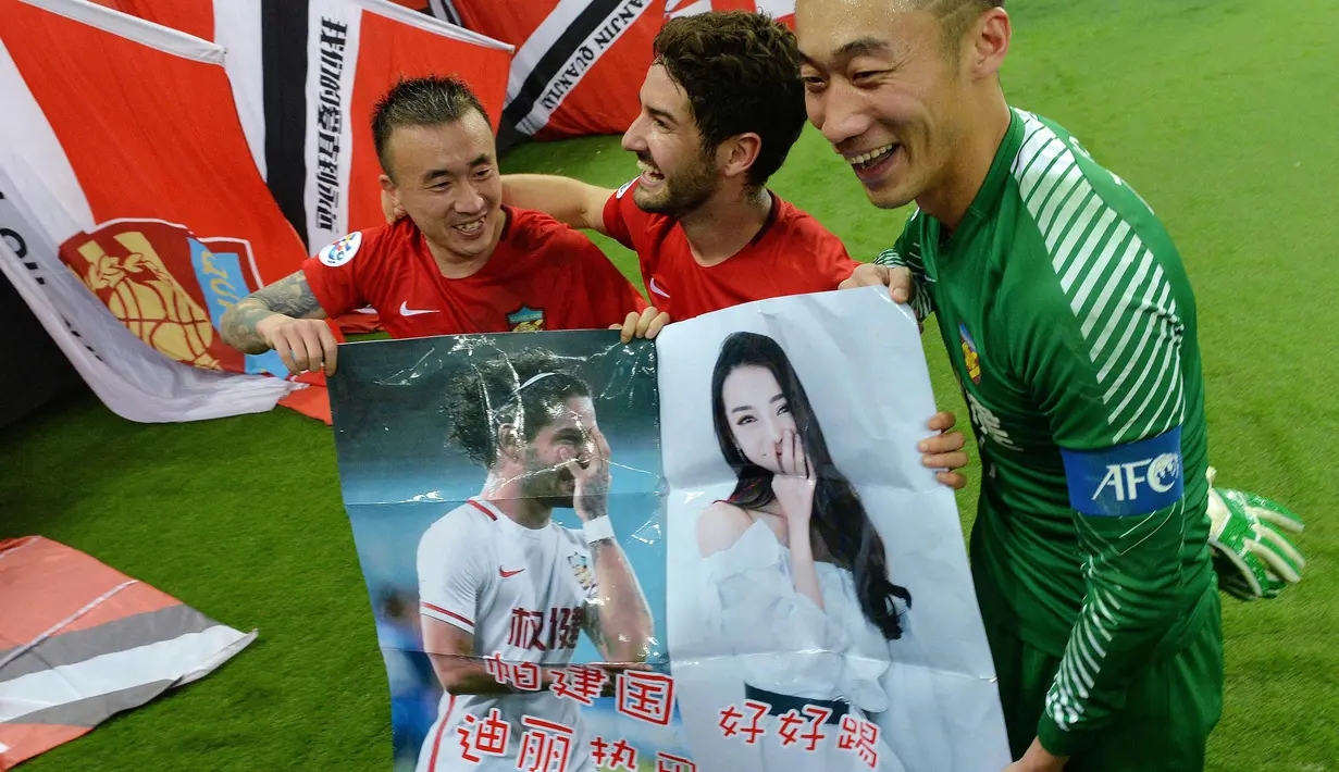 Alexandre Pato membawa poster dirinya dan Dilraba Dilmurat saat melawan South Hyundai Jeonbuk di Liga Champions AFC, Tianjin (14/3). Pekan lalu, Pato mengirim pesan ke Dilmurat yang mengatakan "kamu salah satu orang China yang paling cantik." (AFP Photo)