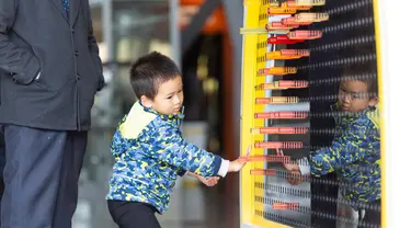 Seorang anak menjajal sebuah perangkat yang dipamerkan di Museum Ilmu Pengetahuan dan Teknologi Nanjing saat Pekan Ilmu Pengetahuan dan Perdamaian Internasional di Nanjing, Provinsi Jiangsu, China timur (11/11/2020). (Xinhua/Zhang Meng)
