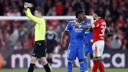 Laga bahkan sempat dihentikan 10 menit saat Vinicius berlari menghampiri wasit Letexier. Penjelasan sang pemain, wasit asal Prancis, Francois Letexier, u membuat gestur tangan menyilang, tanda resmi diaktifkannya protokol anti-rasisme yang resmi dikenalkan FIFA sejak Mei 2024. (AFP/Filipe Amorim)