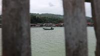 Perahu kecil melintasi Danau Poso di Kelurahan Sangele, Poso. Tampak hunian dan usaha rumah makan berada tepat di tepi danau terbesar ke-3 di Indonesia itu. (Foto: Heri Susanto/ Liputan6.com).