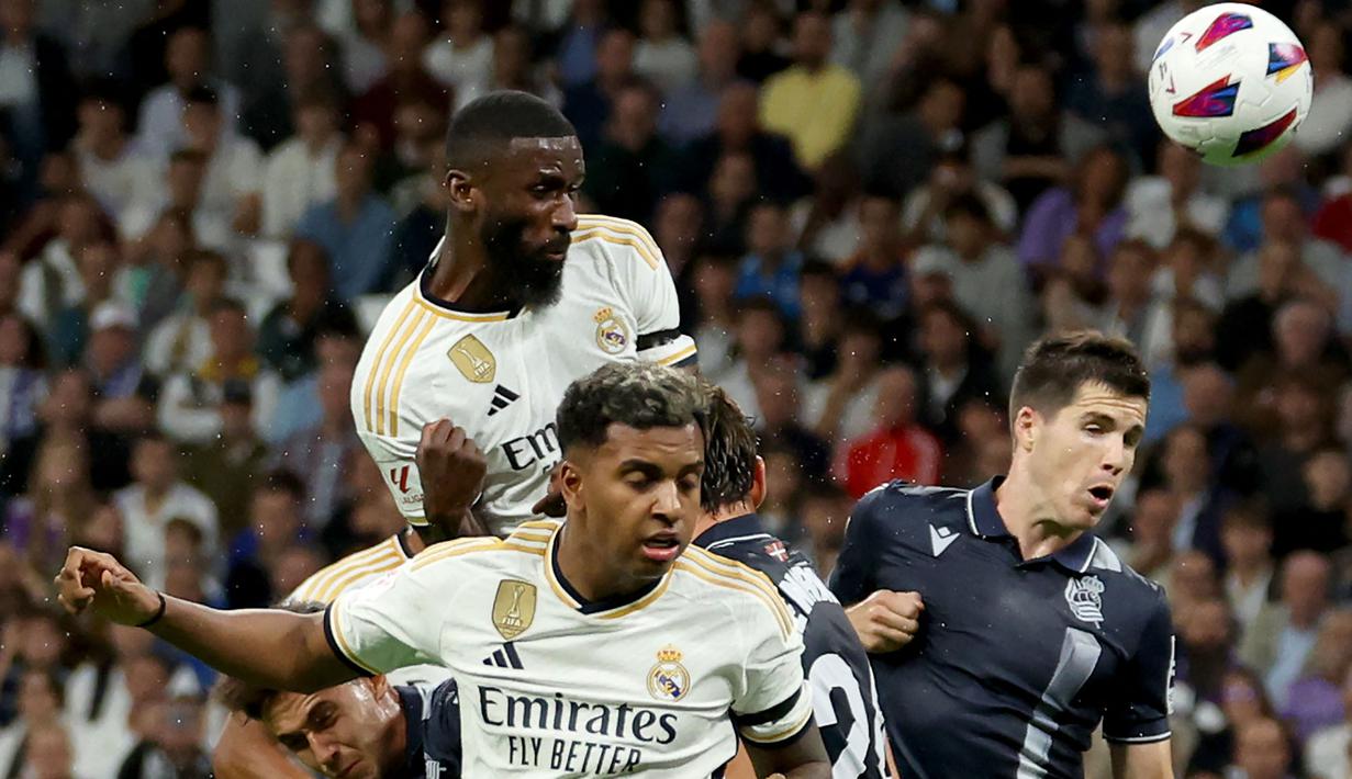 Bek Real Madrid, Antonio Rudiger (atas) menyundul bola dalam sebuah kemelut di depan gawang Real Sociedad pada laga pekan kelima Liga Spanyol 2023/2024 di Santiago Bernabéu Stadium, Madrid, Senin (18/9/2023) dini hari WIB. (AFP/Pierre-Philippe Marcou)