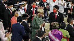 Presiden Joko Widodo (baju hijau) didampingi Ketua DPR Puan Maharani (kedua kiri) memasuki ruang sidang saat menghadiri Sidang Tahunan MPR dan Sidang Bersama DPR - DPD Tahun 2022 di Gedung Nusantara, Kompleks Parlemen, Senayan, Jakarta, Selasa (16/8/2022). Jokowi menyampaikan pidato kenegaraan dalam sidang tahunan MPR RI dan sidang bersama DPR RI dan DPD RI Tahun 2022. (Liputan6.com/Johan Tallo)