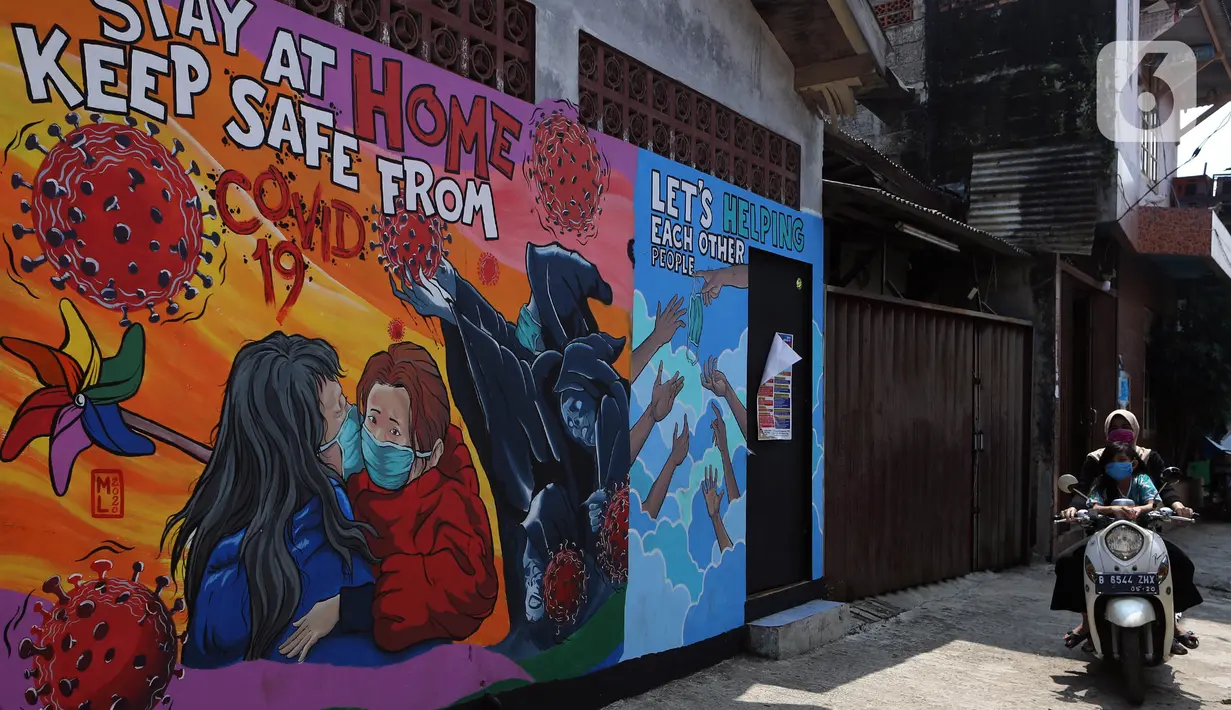 Pemotor melintas di depan mural bertema virus corona COVID-19 yang menghiasi dinding rumah di kawasan Pangkalan Jati Baru, Depok, Jawa Barat, Selasa (2/6/2020). Mural bertulis ‘Stay At Home, Keep Safe From COVID-19’ itu untuk mengingatkan warga akan bahaya COVID-19. (Liputan6.com/Johan Tallo)