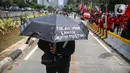 Massa mengenakan payung saat berunjuk rasa di kawasan Patung Kuda, Jakarta, Kamis (22/10/2020). Dalam aksi yang digelar bertepatan dengan setahun pemerintahan Presiden Joko Widodo-Wapres Ma'ruf Amin itu massa meminta dikeluarkannya Perppu pencabutan UU Cipta Kerja. (Liputan6.com/Faizal Fanani)