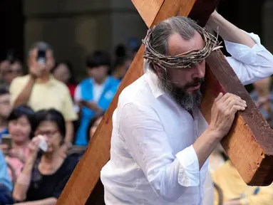 Rafael Haddad memikul salib sambil memerankan Yesus ketika anggota Gereja Misi Wesley melakukan interpretasi modern tentang penyaliban Kristus pada peringatan Jumat Agung di Sydney, Australia, Jumat (7/4/2023). (AP Photo/Rick Rycroft)