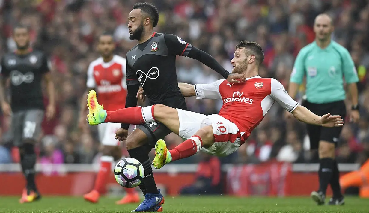 Gelandang Southampton, Nathan Redmond, berebut bola dengan bek Arsenal, Shkodran Mustafi. Tertinggal 0-1 membuat pasukan Meriam London terus melancarkan serangan, namun sayang sembilan kali tembakannya melenceng. (Reuters/Dylan Martinez)