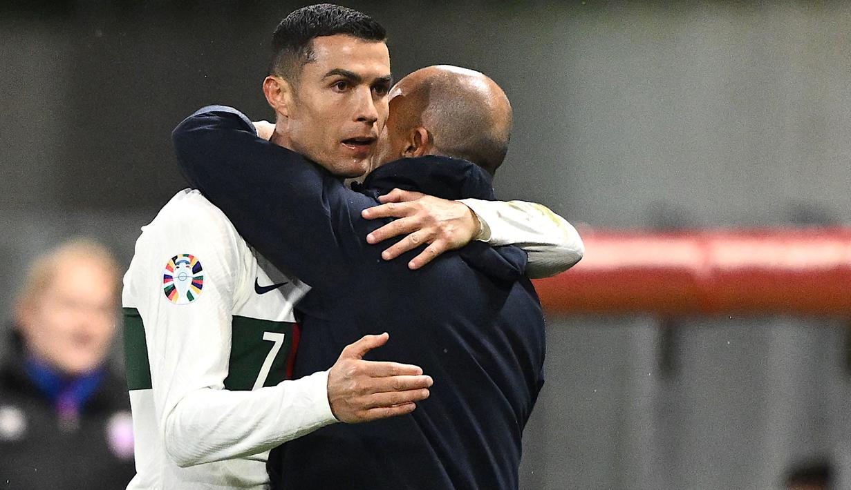 Striker Timnas Portugal, Cristiano Ronaldo memeluk pelatih Roberto Martinez setelah ia ditarik keluar untuk digantikan oleh Bruma pada laga lanjutan Grup J Kualifikasi Euro 2024 di Rheinpark Stadium, Vaduz, Jumat (17/11/2023) dini hari WIB. (AFP/Sebastien Bozon)