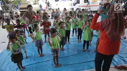 Anak-anak TK menari di kamp pengungsian Gor Swace Pura, Klungkung, Bali, Kamis (28/09). Kegiatan tersebut bertujuan menghilangkan rasa trauma serta sebagai sarana bermain anak korban bencana alam. (Liputan6.com/Gempur M Surya)