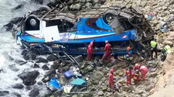 Petugas pemadam kebakaran mengevakuasi tubuh korban dari sebuah bus yang jatuh dari tebing di Pasamayo, Peru, Selasa (3/1). Penumpang bus sebagian besar kembali ke Lima, setelah merayakan liburan Tahun Baru bersama keluarga di luar kota. (HO/ANDINA/AFP)