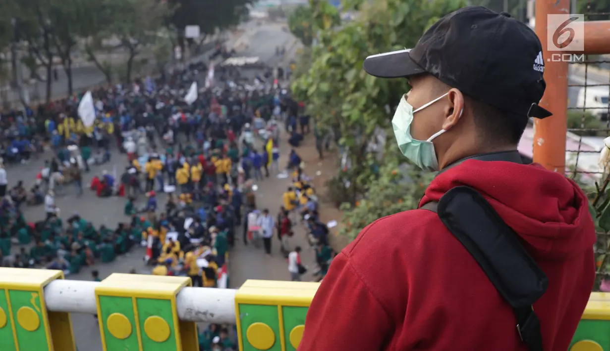 Warga menyaksikan aksi unjuk rasa yang dilakukan mahasiswa dari berbagai perguruan tinggi di sekitar Jembatan Layang Gerbang Pemuda, Jakarta, Selasa (1/10/2019). Mahasiswa dari berbagai perguruan tinggi kembali berunjuk rasa menolak beberapa RUU. (Liputan6.com/Helmi Fithriansyah)