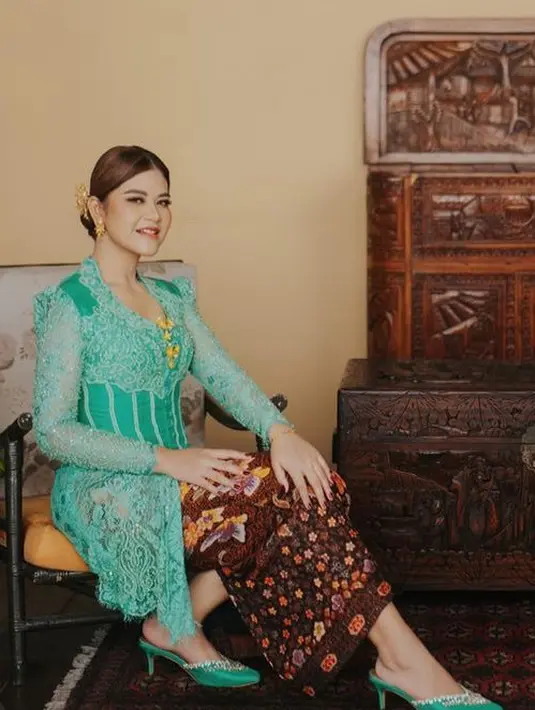 Kahiyang Ayu tampil mengenakan kebaya hijau brokat dengan aksen korset. Dipaduk bros keemasan dan kain batik sebagai bawahan. Ia pun memadukannya dengan stiletto kitten heels warna senada. [@garyevan/@allseasonphoto]