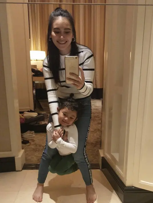 Nah kalau yang satu ini keduanya kompak pakai celana jeans dengan atasan putih. Meskipun atasan yang dikenakan Ayu bermotif garis sedangkan Bilqis hanya putih polos. (Instagram/ayutingting92)