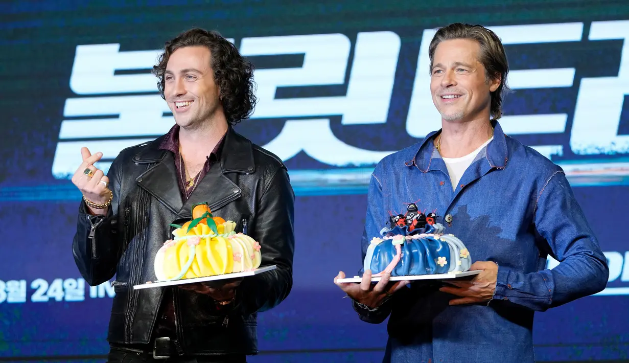 Brad Pitt (kanan) dan Aaron Taylor-Johnson berpose untuk media dengan kue sebelum konferensi pers untuk mempromosikan film terbaru mereka Bullet Train di Seoul, Korea Selatan, 19 Agustus 2022. Film ini akan dirilis di Korea Selatan pada 24 Agustus. (AP Photo/Lee Jin-man)