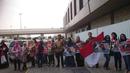 Warga Indonesia membawa bendera dan tulisan dukungan saat menyambut kedatangan pebalap Manor Racing asal Indonesia, Rio Haryanto, di Bandar Udara Internasional Bahrain, Selasa (29/3/206). (Bola.com/Twitter)