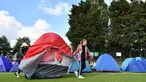 Dua wanita memindahkan tenda mereka ketika mengantre untuk membeli tiket pada hari pertama turnamen tenis Kejuaraan Wimbledon 2019 di The All England Tennis Club di Wimbledon, London barat daya (1/7/2019). Turnamen ini dimulai 1 Juli-14 Juli 2019. (AFP Photo/Ben Stansall)