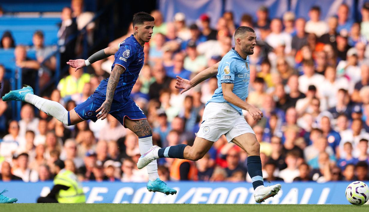 Pemain Manchester City, Mateo Kovacic (kanan) berebut bola dengan pemain Chelsea, Enzo Fernandez pada laga Liga Inggris 2024/2025 di Stamford Bridge, London, Inggris, Minggu (18/08/2024) malam WIB. (AFP/Adrian Dennis)