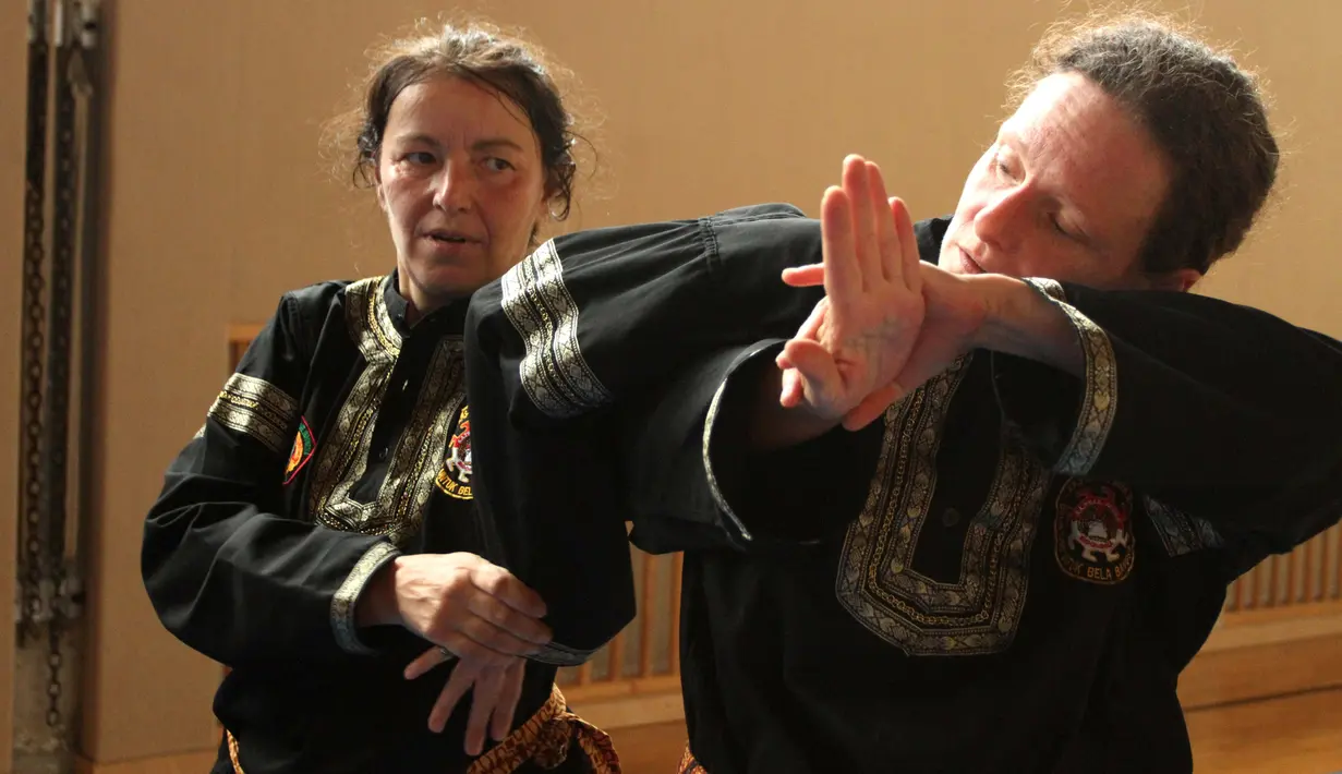 Dua murid wanita sekolah pencak silat Anak Harimau tengah memperagakan teknik serangan. (Bola.com/Reza Khomaini)