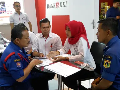 Karyawan Bank DKI menjelaskan aplikasi JakOne Mobile kepada pengunjung Pekan Raya Jakarta di Jakarta (23/5). Bank DKI turut berpartisipasi dalam PRJ yang digelar mulai tanggal 23 Mei hingga 1 Juni. (Liputan6.com/Pool/Budi)