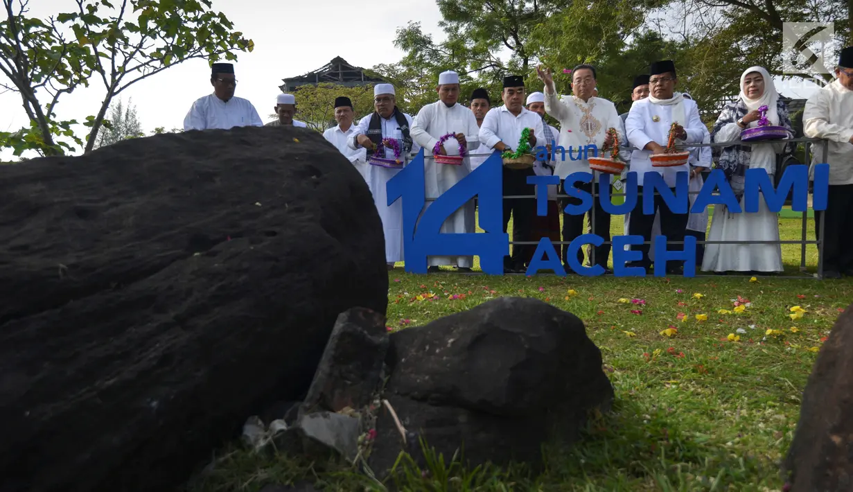 Walikota Higashi Matsusima, Jepang, Iwao Atsumi (tengah) bersama ulama dan tokoh masyarakat menabur bunga saat peringatan 14 tahun tsunami di Kuburan Massal Ulee Lheue, Banda Aceh, Rabu (26/12). (Chaideer MAHYUDDIN / AFP)