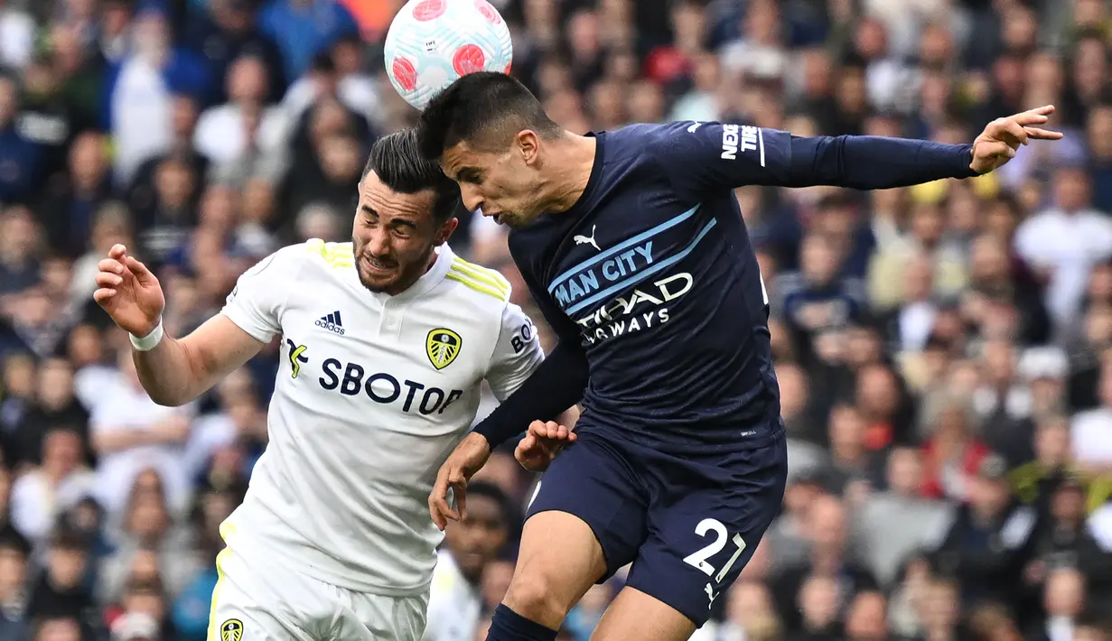 <p>Gelandang Leeds United, Jack Harrison (kiri) bersaing dengan bek Manchester City, Joao Cancelo pada pertandingan lanjutan Liga Inggris di Elland Road di Leeds, Inggris utara (30/4/2022). City menang telak atas Leeds 4-0. (AFP/Oli Scarff)</p>