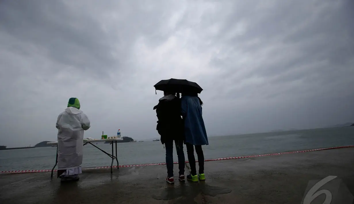 Meski hujan mengguyur, keluarga korban tetap setia menunggu Tim SAR untuk mendapat informasi tentang keluarganya yang hilang di tragedy Feri Sewol, Minggu (27/04/2014) (Reuters/ Kim Kyung-Hoon).