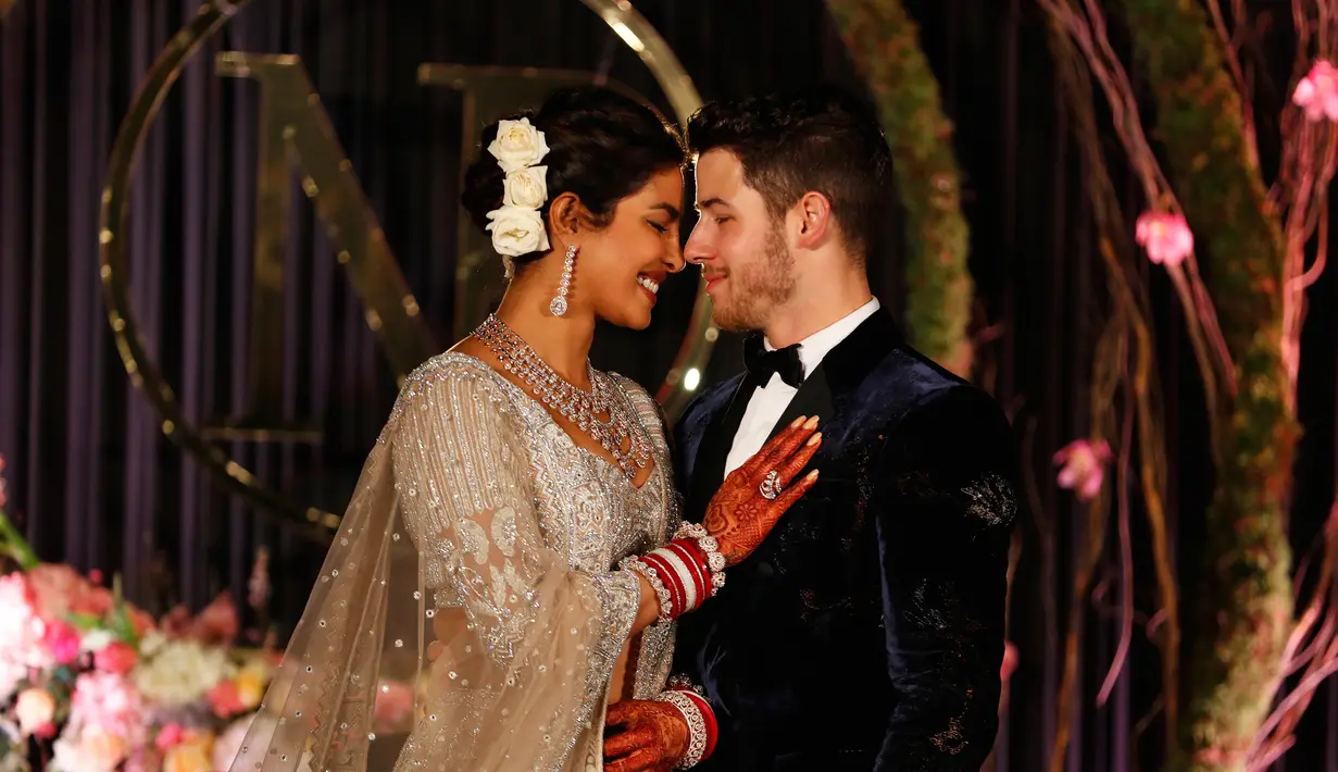 Aktris Bollywood Priyanka Chopra dan musisi AS Nick Jonas berpose saat resepsi pernikahan mereka di New Delhi, India, Selasa (4/12). Keduanya berkali-kali melepas senyum bahagia kepada publik. (AP Photo/Altaf Qadri)