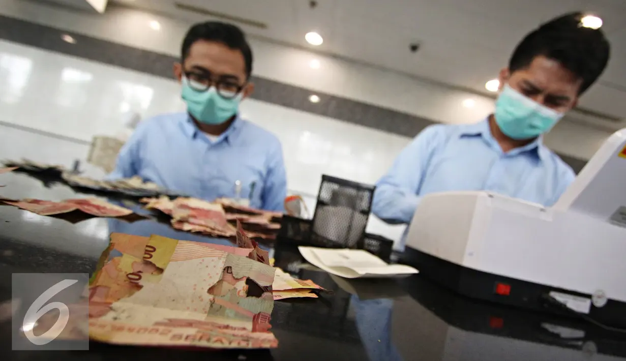 Petugas mengecek uang rusak yang ditukarkan di Bank Indonesia, Jakarta, Senin (6/6). BI meminta masyarakat menukarkan uang yang sudah tidak layak edar dengan uang baru agar uang yang beredar tetap berkualitas tinggi. (Liputan6.com/Immanue Antonius)