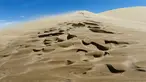 Seorang turis berdiri di atas bukit pasir Taman Nasional Altynemel, Almaty, Kazakhstan, 12 Mei 2016. Bukit pasir yang membentang hingga 3 km dan tinggi 30 m ini dapat menghasilkan gemuruh bernada rendah yang seolah-olah bernyanyi (REUTERS/Shamil Zhumatov)