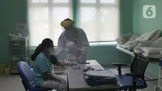 Paramedis melakukan observasi kepada seorang pasien positif COVID-19 yang dirawat di Puskesmas Jurumudi, Tangerang, Banten, Kamis (17/2/2022). Kasus positif COVID-19 di Kota Tangerang terus mengalami penurunan kasus dari 2000 kasus perhari menjadi 1000 kasus perhari. (merdeka.com/Arie Basuki)