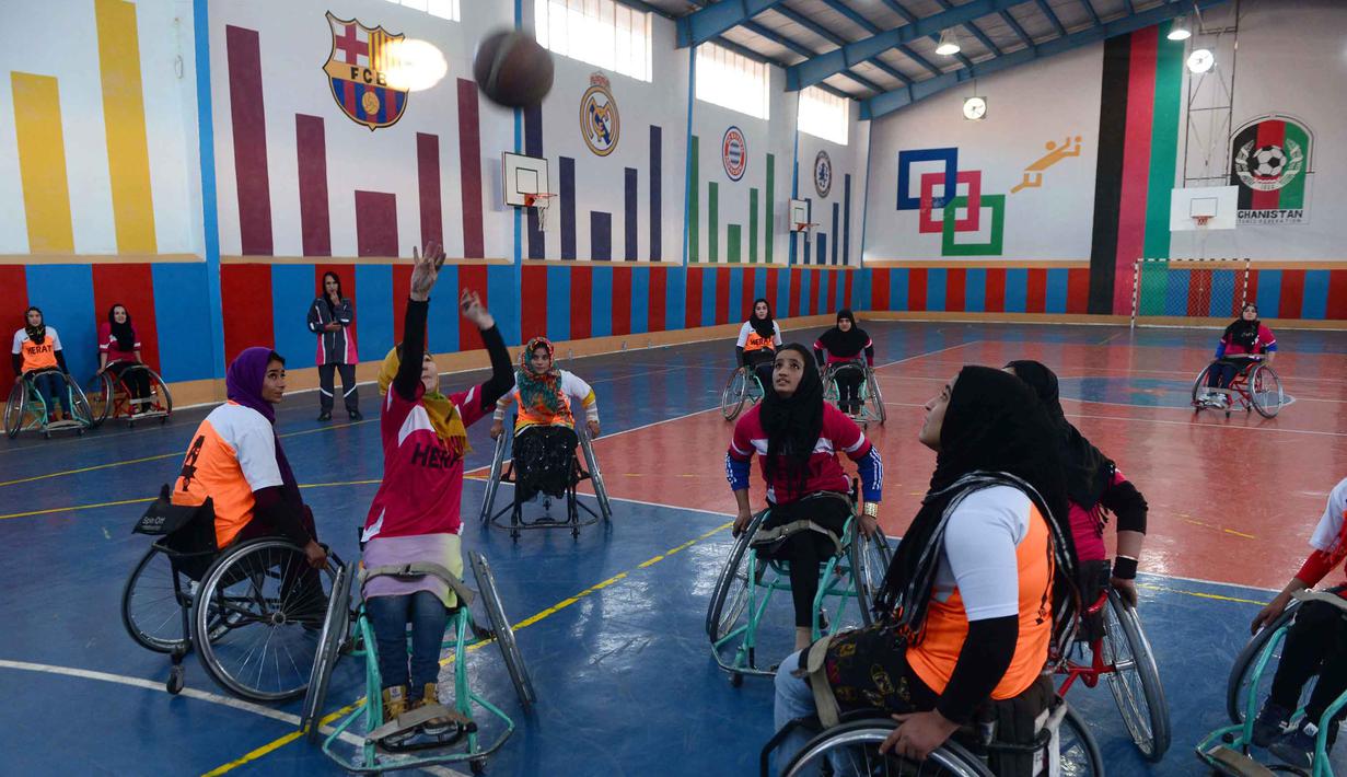  Tim Kahkashan (orange) dan tim Sitara (merah) beraksi pada Turnamen Basket Kursi Roda untuk penyandang cacat di Provinsi Herat, Afghanistan, Minggu (29/11/2015). (AFP Photo/Aref Karimi).