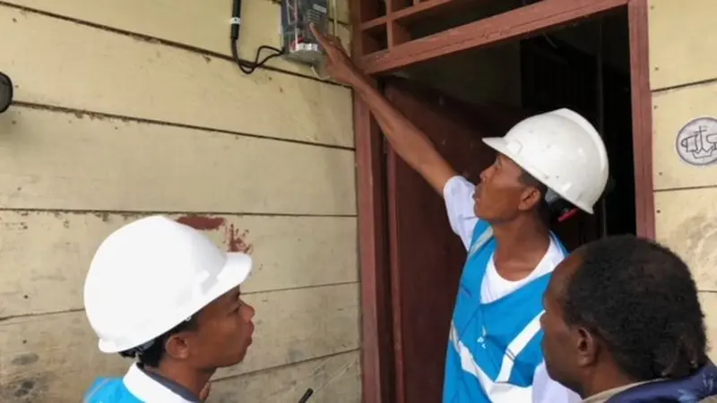 Petugas PLN memasang listrik di rumah warga di Desa Parauto, Nabire, Papua. (Vina A. Muliana/Liputan6.com)
