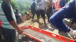 Petugas penyelamat menggunakan tandu untuk mengevakuasi penumpang bus yang terjun ke jurang di Kota Carranglan, Provinsi Nueva Ecija di Filipina Utara, Selasa (18/4). Bus terjun ke dalam jurang sedalam 24 meter di kawasan pegunungan. (Handout/MDRRMO/AFP)