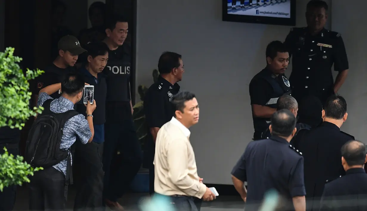WN Korut Ri Jong Chol (kedua kiri) dikawal anggota polisi meninggalkan markas Polisi Sepang, Malaysia, Jumat (3/3). Malaysia membebaskan pria Korea Utara yang diduga terlibat pembunuhan Kim Jong-nam itu karena tidak memiliki cukup bukti. (MOHD RASFAN/AFP)