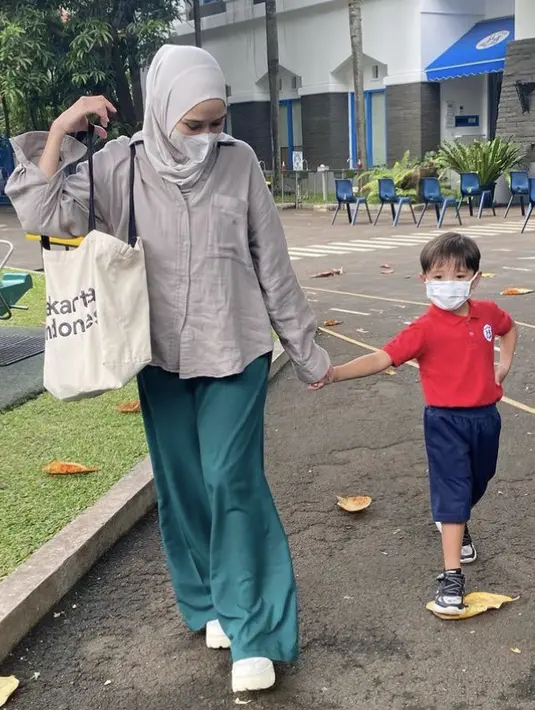 <p>Zaskia Adya Mecca pun mengantar sekolah anak laki-lakinya. Ia tampil kasual mengenakan kemeja lengan panjang oversize warna abu-abu dipadukan celana hijau dan sneakers putihnya. @zaskiaadyamecca</p>