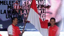 Rio Haryanto (kanan) menerima bendera Merah Putih dari Menpora Imam Nahrawi usai dipastikan bergabung dengan tim Manor Racing F1 di Jakarta, Kamis (18/2/2016). Rio akan mengikuti Formula 1 selama semusim penuh. (Liputan6.com/Helmi Fithriansyah)